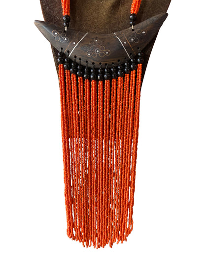 Statement-Kette mit geschnitztem Ebenholz-Horn-Anhänger und leuchtend oranger Perlenfranse