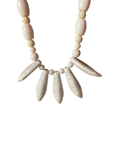 Elegante Halskette mit geschnitzten Knochenanhängern und cremefarbenen Perlen